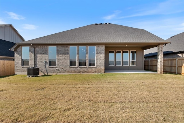 rear view of house with central AC, a yard, and a patio