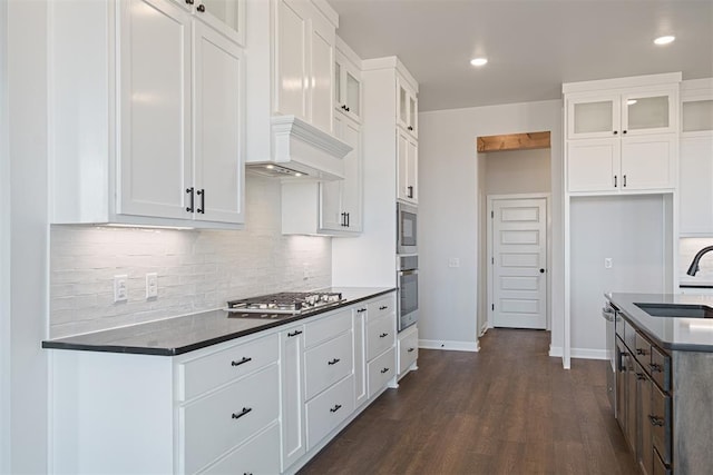13268 Sawtooth Oak Rd, Choctaw, OK 73020 - kitchen featuring appliances with stainless steel finishes, dark countertops, decorative backsplash, dark wood finished floors, and glass insert cabinets