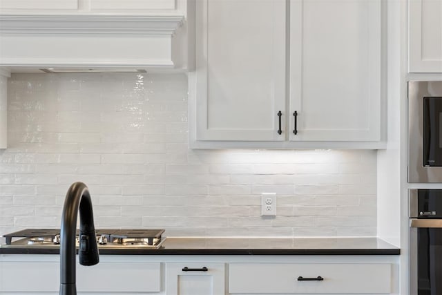 13268 Sawtooth Oak Rd, Choctaw, OK 73020 - kitchen with backsplash, white cabinetry, appliances with stainless steel finishes, and dark countertops