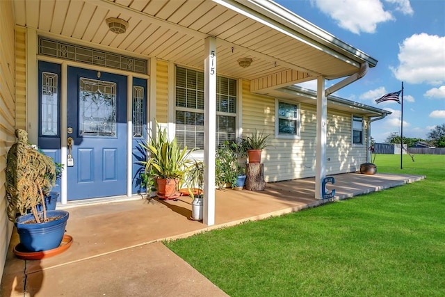 property entrance with a lawn and covered porch