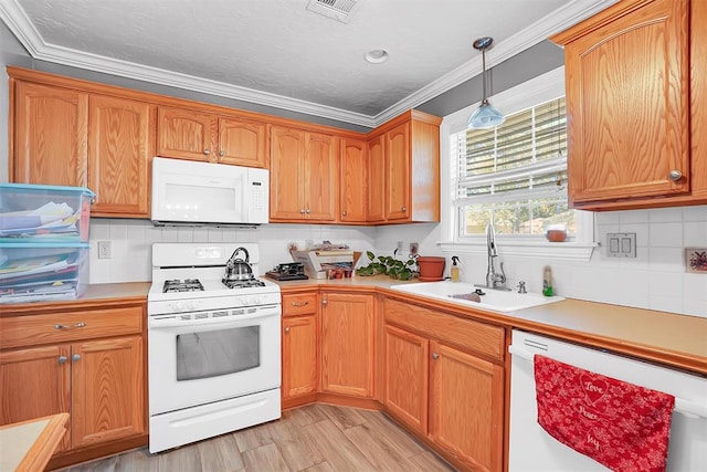 kitchen featuring sink, light hardwood / wood-style flooring, decorative light fixtures, white appliances, and ornamental molding