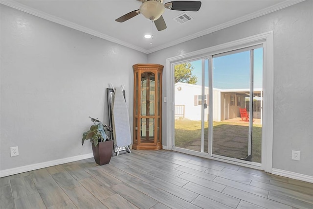 empty room with ceiling fan, light wood-type flooring, and crown molding