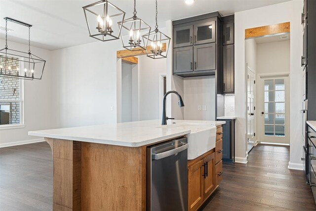 kitchen featuring light stone countertops, pendant lighting, dishwasher, dark hardwood / wood-style floors, and an island with sink