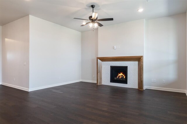 unfurnished living room with a high end fireplace, dark hardwood / wood-style floors, and ceiling fan