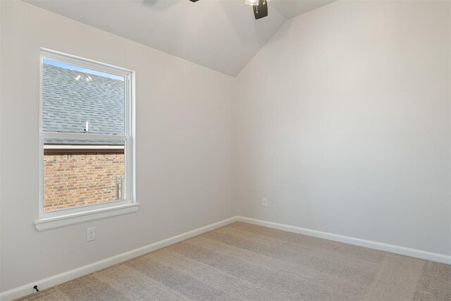 carpeted spare room with ceiling fan and lofted ceiling