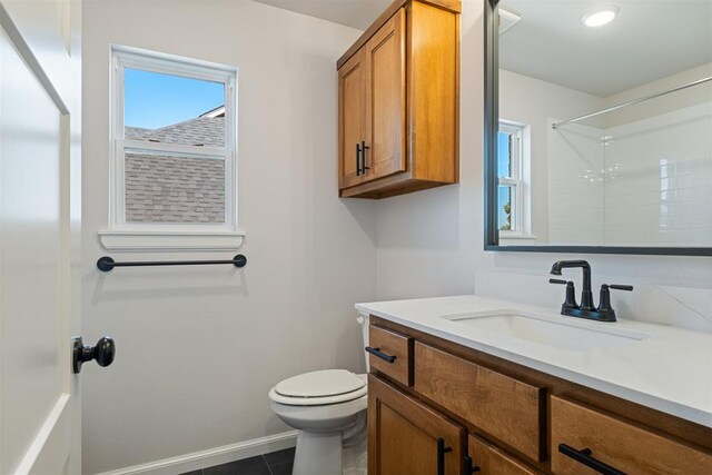 bathroom with tile patterned floors, vanity, toilet, and a shower