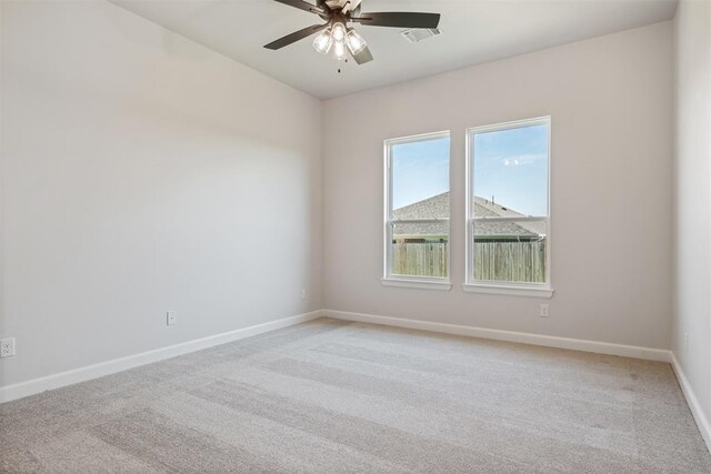 empty room featuring ceiling fan and carpet