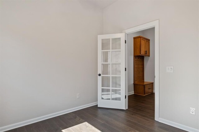 spare room featuring dark hardwood / wood-style floors and french doors