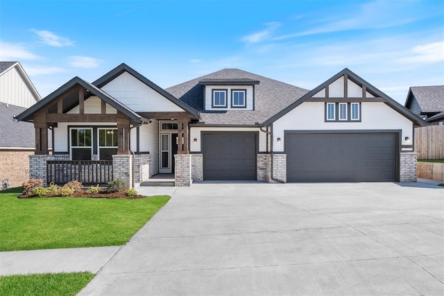 view of front of property with covered porch, a garage, and a front yard