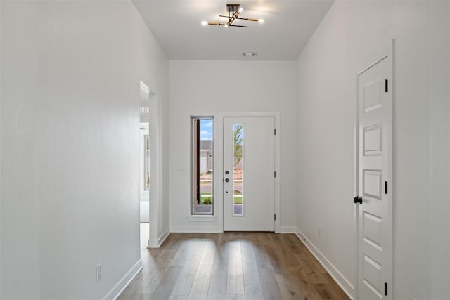 entryway with a chandelier and wood-type flooring