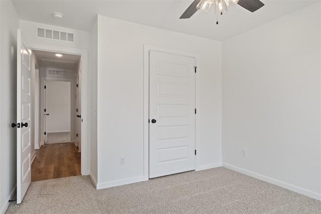 unfurnished bedroom featuring light carpet, a closet, and ceiling fan