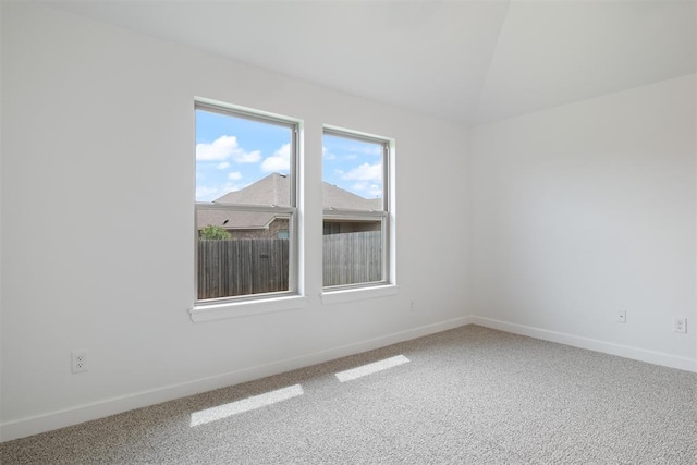 carpeted spare room with lofted ceiling