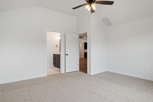 unfurnished bedroom with ensuite bathroom, high vaulted ceiling, ceiling fan, and light colored carpet