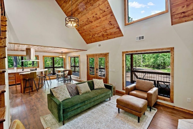 living room with hardwood / wood-style floors, wooden ceiling, high vaulted ceiling, and an inviting chandelier