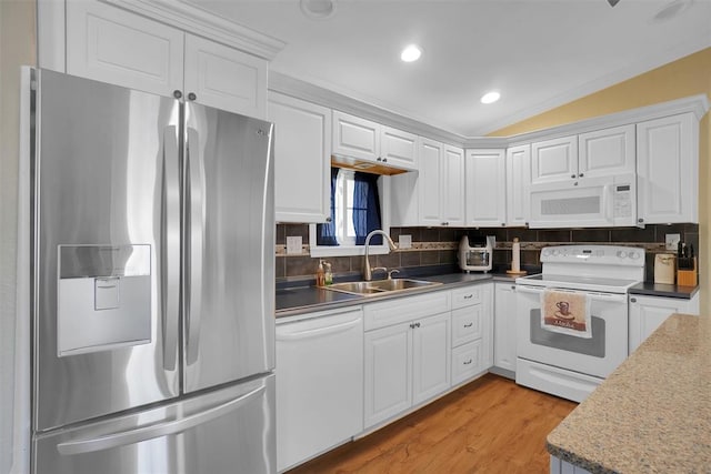 kitchen featuring white cabinets, white appliances, lofted ceiling, and sink