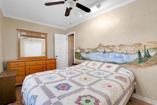 bedroom with wood-type flooring, rail lighting, ceiling fan, and ornamental molding