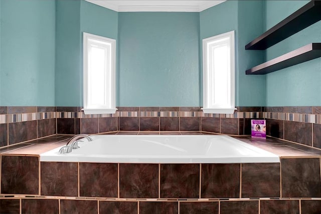 bathroom featuring tiled tub, crown molding, and plenty of natural light