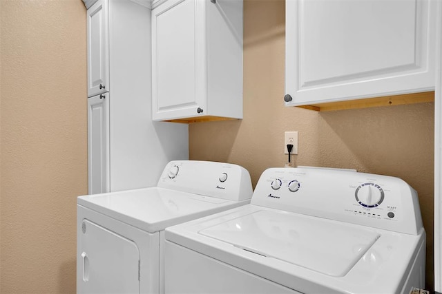 laundry room with cabinets and washer and clothes dryer