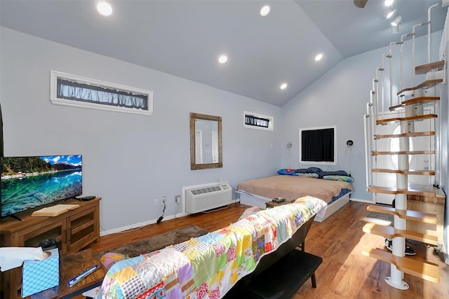 bedroom with a wall mounted air conditioner, hardwood / wood-style floors, and lofted ceiling