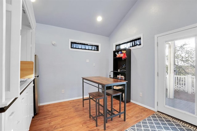 dining area featuring lofted ceiling and light hardwood / wood-style flooring