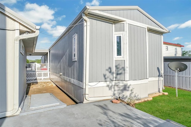 view of home's exterior with a storage unit and a yard