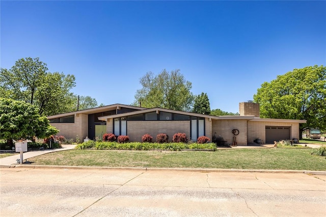 view of front of property featuring a garage and a front lawn