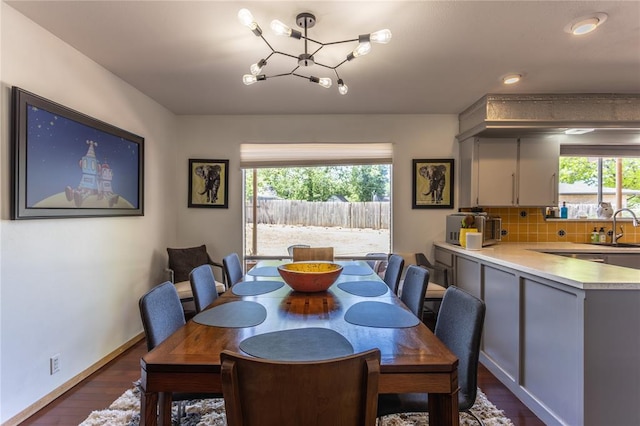 dining area with a notable chandelier, a healthy amount of sunlight, dark hardwood / wood-style flooring, and sink