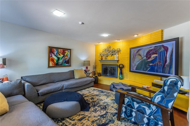 living room featuring a brick fireplace and hardwood / wood-style flooring