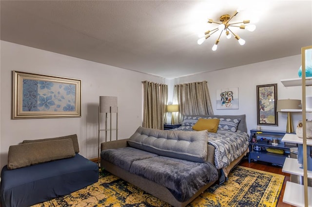 bedroom with hardwood / wood-style floors and a notable chandelier