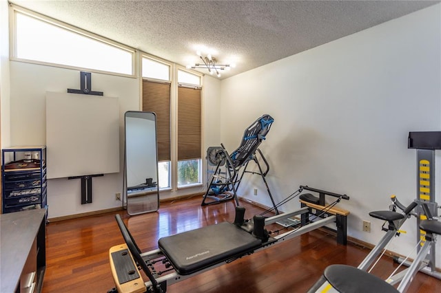 exercise area with dark hardwood / wood-style floors and a textured ceiling