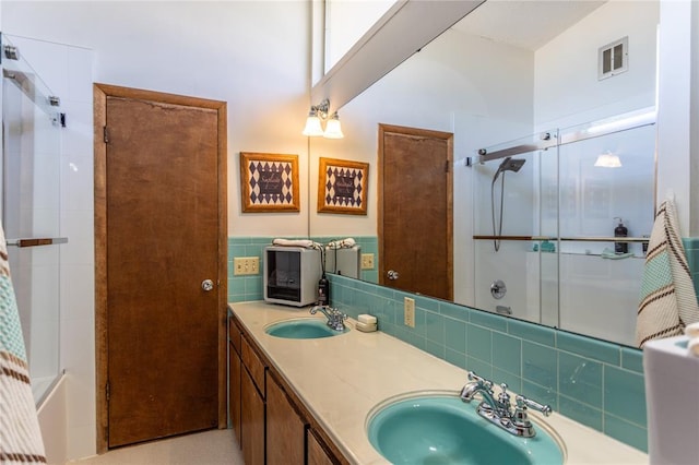 bathroom featuring vanity and bath / shower combo with glass door