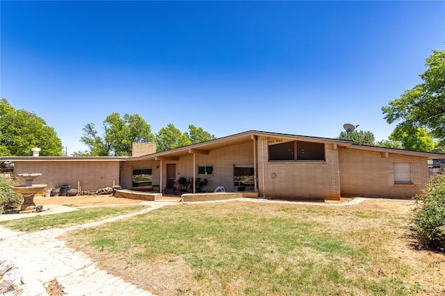 back of property featuring a yard