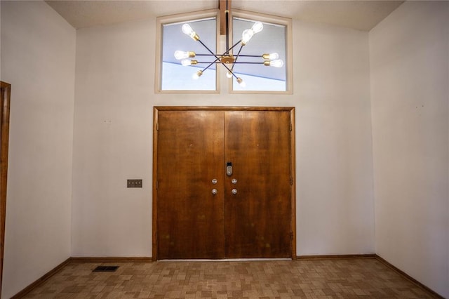 entryway featuring a notable chandelier and lofted ceiling