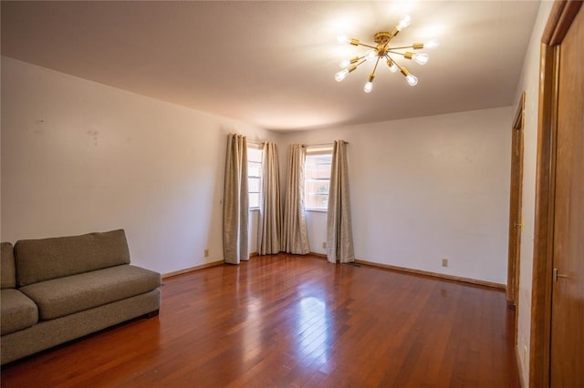 unfurnished living room featuring hardwood / wood-style flooring and a chandelier