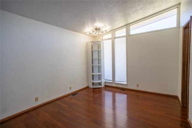 spare room with hardwood / wood-style floors and a textured ceiling