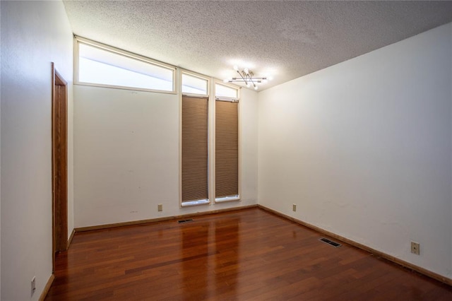 unfurnished room featuring hardwood / wood-style floors and a textured ceiling