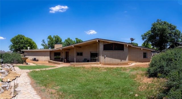 rear view of house featuring a yard