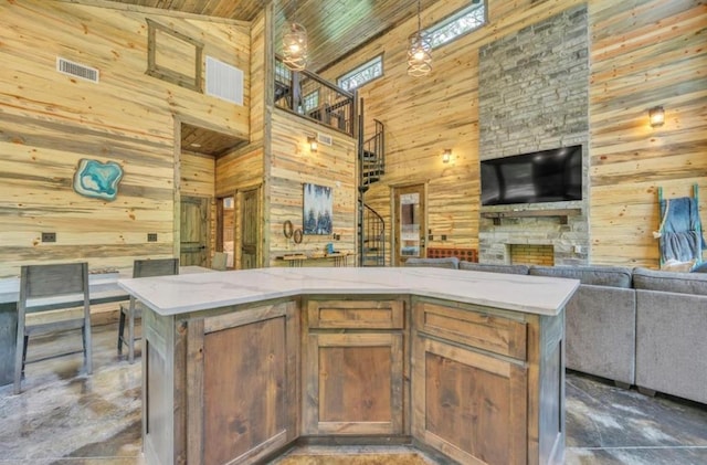 kitchen with wooden walls, a center island, and high vaulted ceiling