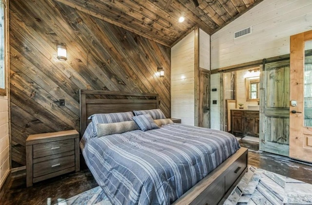 bedroom featuring wood walls, a barn door, wooden ceiling, and connected bathroom