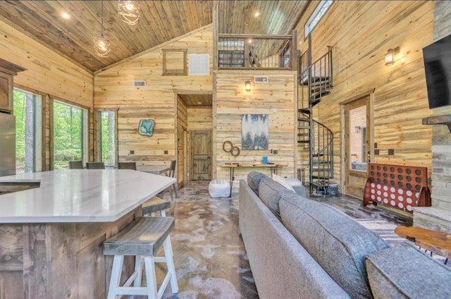 unfurnished living room featuring concrete flooring, wooden walls, high vaulted ceiling, and wooden ceiling