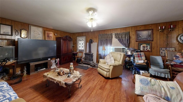 living room featuring wood walls, light wood-type flooring, and a wood stove