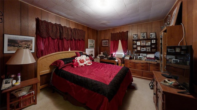 bedroom featuring light carpet and wood walls