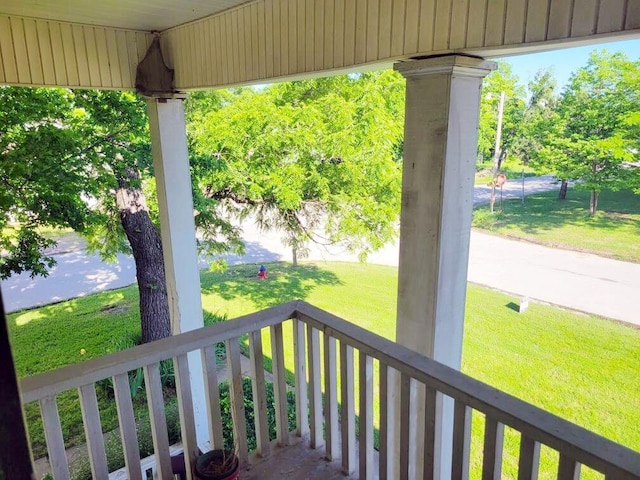 wooden deck with a water view and covered porch