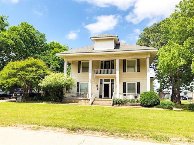 greek revival inspired property featuring a porch, a balcony, and a front lawn