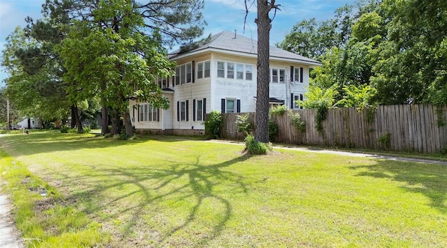 exterior space with fence and a lawn