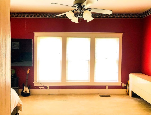 bedroom featuring visible vents, multiple windows, and a ceiling fan