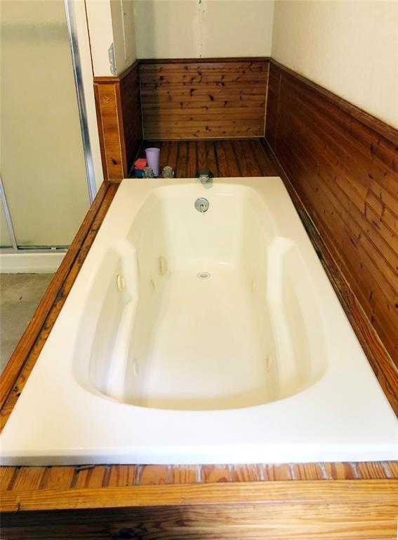 bathroom with a shower stall and a whirlpool tub