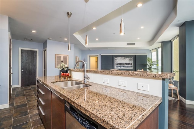 kitchen with stainless steel dishwasher, a kitchen island with sink, dark wood-type flooring, sink, and hanging light fixtures