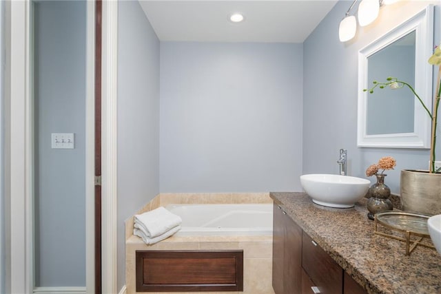 bathroom with vanity and a relaxing tiled tub