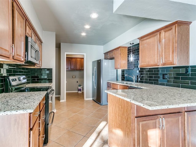 kitchen with decorative backsplash, light stone countertops, light tile patterned flooring, and appliances with stainless steel finishes